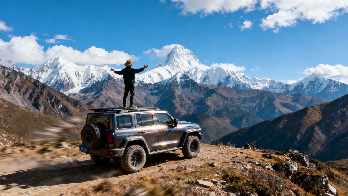 Traveler on SUV roof with snowy mountains